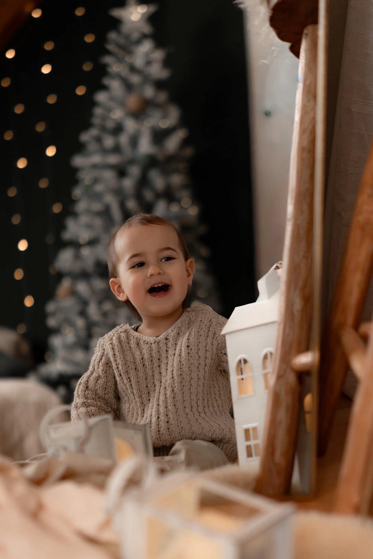 Kind entdeckt die Weihnachtskulisse mit leuchtendem Lichthaus